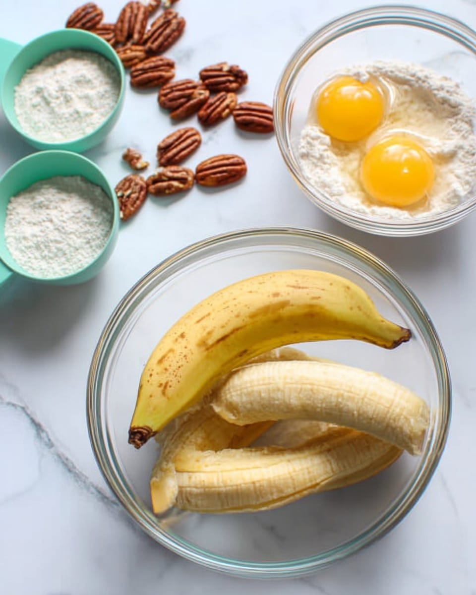 A clear glass bowl with three peeled bananas inside, resting on a white marbled surface. To the right of the bowl, a small clear glass bowl contains two raw eggs with bright yellow yolks. On the left side, there are some pecan nuts scattered on the white marbled surface and two green measuring cups filled with white sugar and flour. The scene is brightly lit, showing all the textures clearly. Photo taken with an iphone --ar 4:5 --v 7