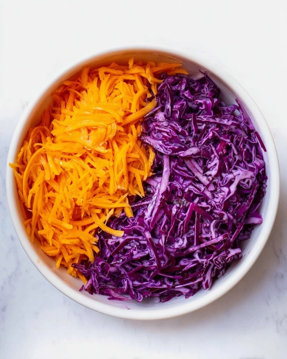 A white bowl filled with two layers of shredded vegetables evenly divided in a yin-yang shape: one side has bright orange shredded carrots with a soft texture, and the other side has finely sliced purple cabbage with a slightly glossy, crisp look. The bowl sits on a white marbled surface. photo taken with an iphone --ar 4:5 --v 7