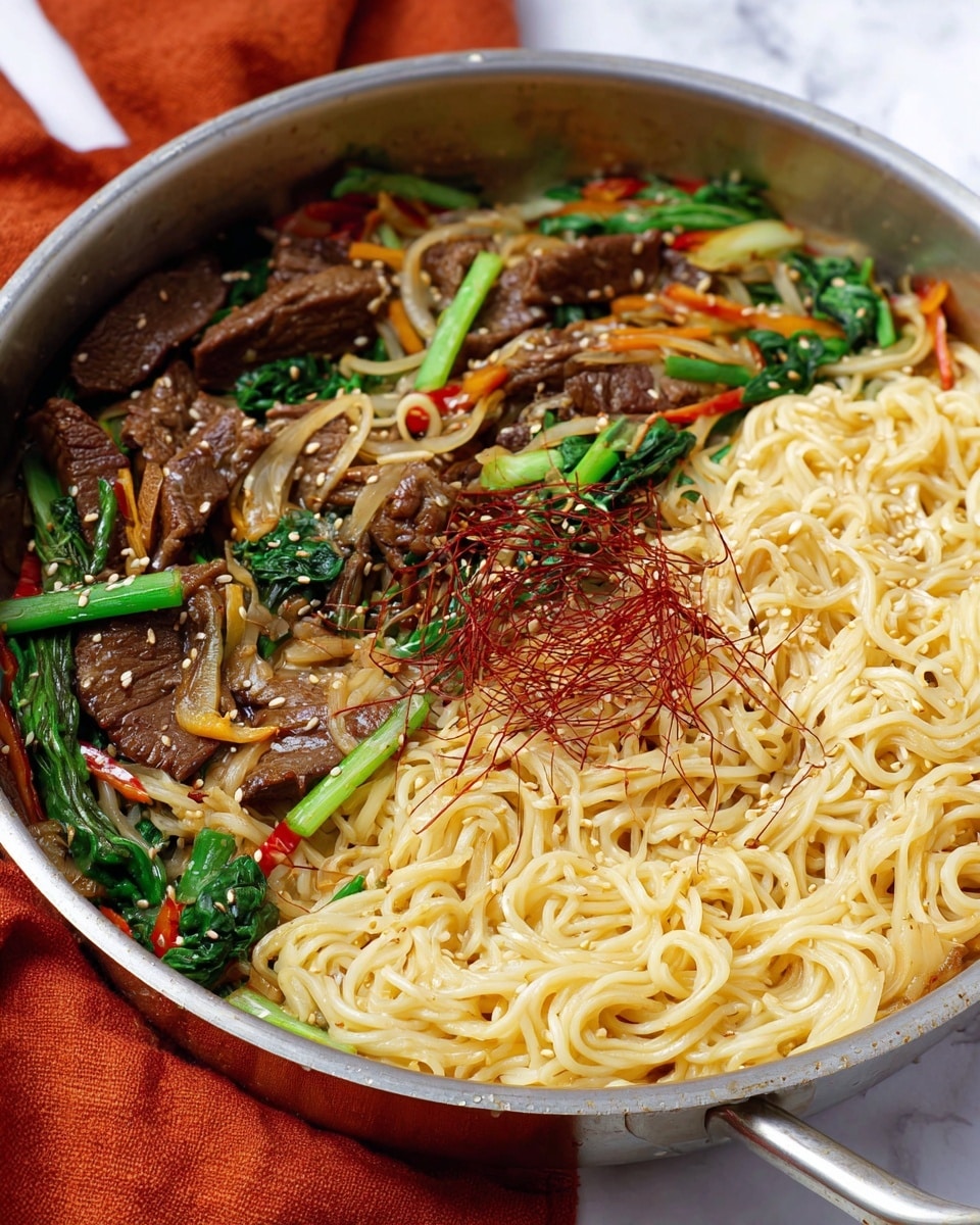A large silver pan filled with three layers of stir-fried food: the bottom layer has light yellow noodles with smooth texture, the middle layer has pieces of dark brown meat scattered evenly, and the top layer is a mix of green leafy vegetables, thin strips of red peppers, light brown sesame seeds, and thin dark reddish strands spread across. The pan is placed on a white marbled surface with an orange cloth in the background. Photo taken with an iphone --ar 4:5 --v 7