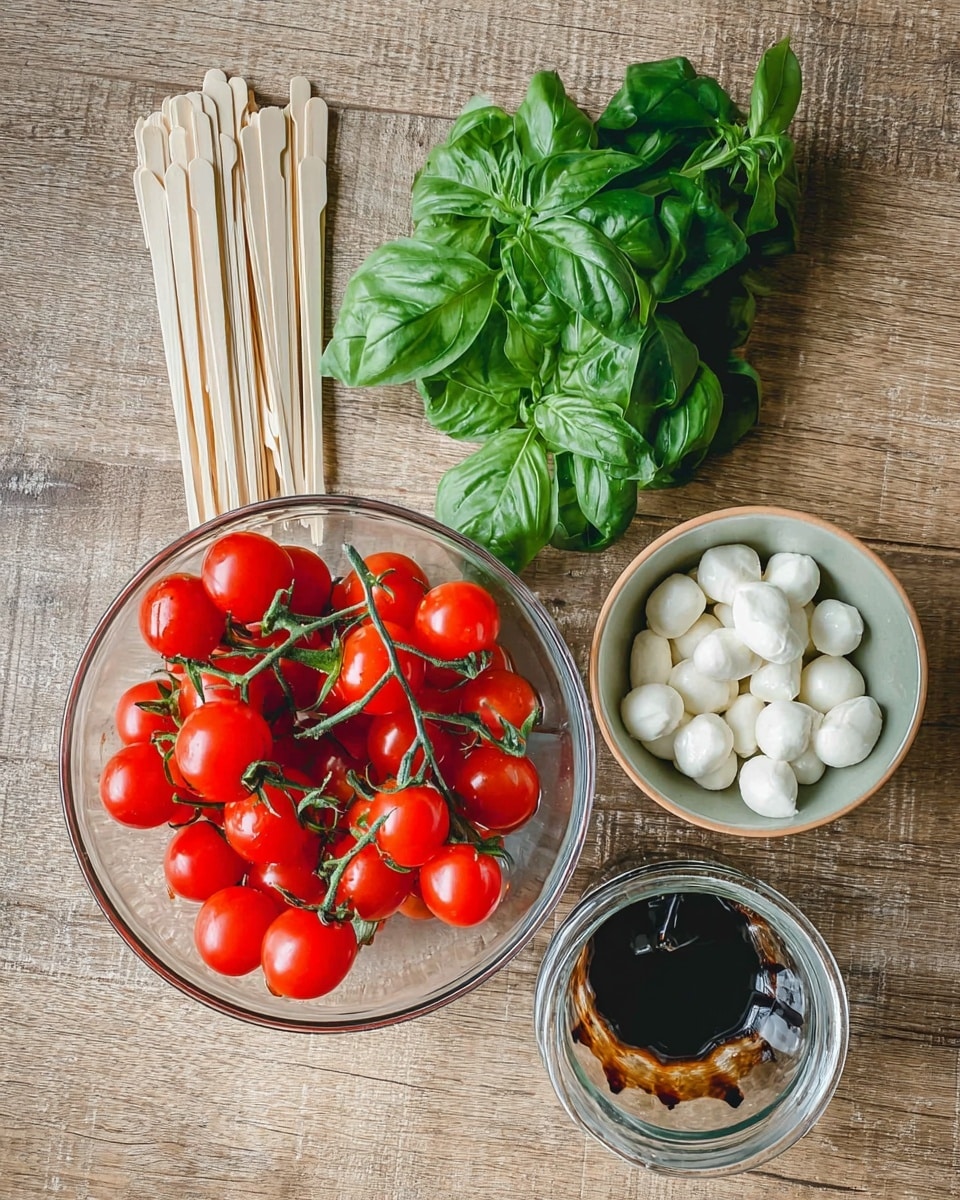 The image shows three clear bowls on a wooden surface with fresh ingredients: one large bowl filled with bright red cherry tomatoes still on green stems, one smaller bowl filled with small white mozzarella balls, and one empty jar with dark balsamic vinegar residue inside. Next to the bowls lies a bunch of fresh green basil leaves and a pack of light beige wooden cocktail forks. The whole setting is on a simple wooden table with light textures. photo taken with an iphone --ar 4:5 --v 7