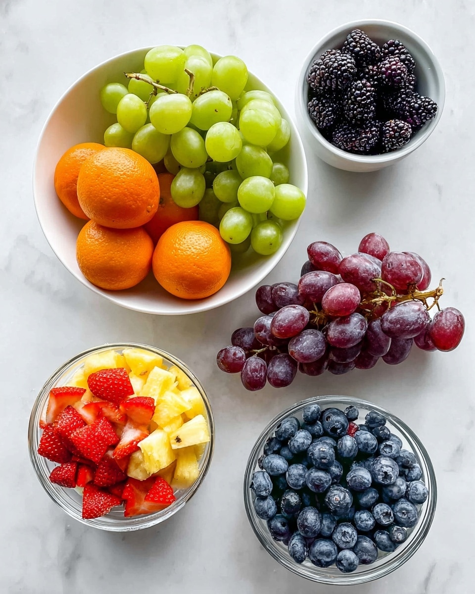 A white bowl filled with green grapes and a smaller bunch of dark red grapes rests slightly to the right on a white marbled surface. Above it is a small white bowl filled with blackberries. On the left, three whole bright orange tangerines sit spaced apart. Below the grapes is a clear bowl layered with pineapple chunks on top and red strawberry pieces beneath. To the right of this bowl is another clear bowl filled with round, plump blueberries. The colors of the fruit are bright and fresh, contrasting with the clean white bowls and marbled background. photo taken with an iphone --ar 4:5 --v 7