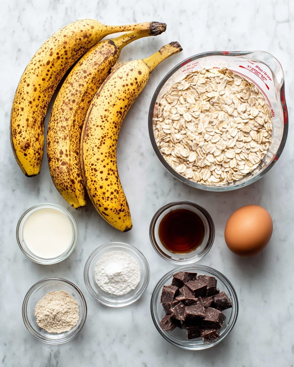The image shows three ripe bananas with brown spots placed on a white marbled surface on the left side. To the right of the bananas, there is a clear glass bowl filled with light beige rolled oats. Above the oats is a clear measuring cup with milk inside, showing measurement marks in red. Near the bottom right corner, there is one brown egg. Around the egg and oats, four small clear bowls hold different ingredients: one with white powder, one with brown and white powders mixed, one with vanilla extract showing a dark brown liquid, and one with chunks of dark chocolate. The background is a smooth white marbled surface. photo taken with an iphone --ar 4:5 --v 7