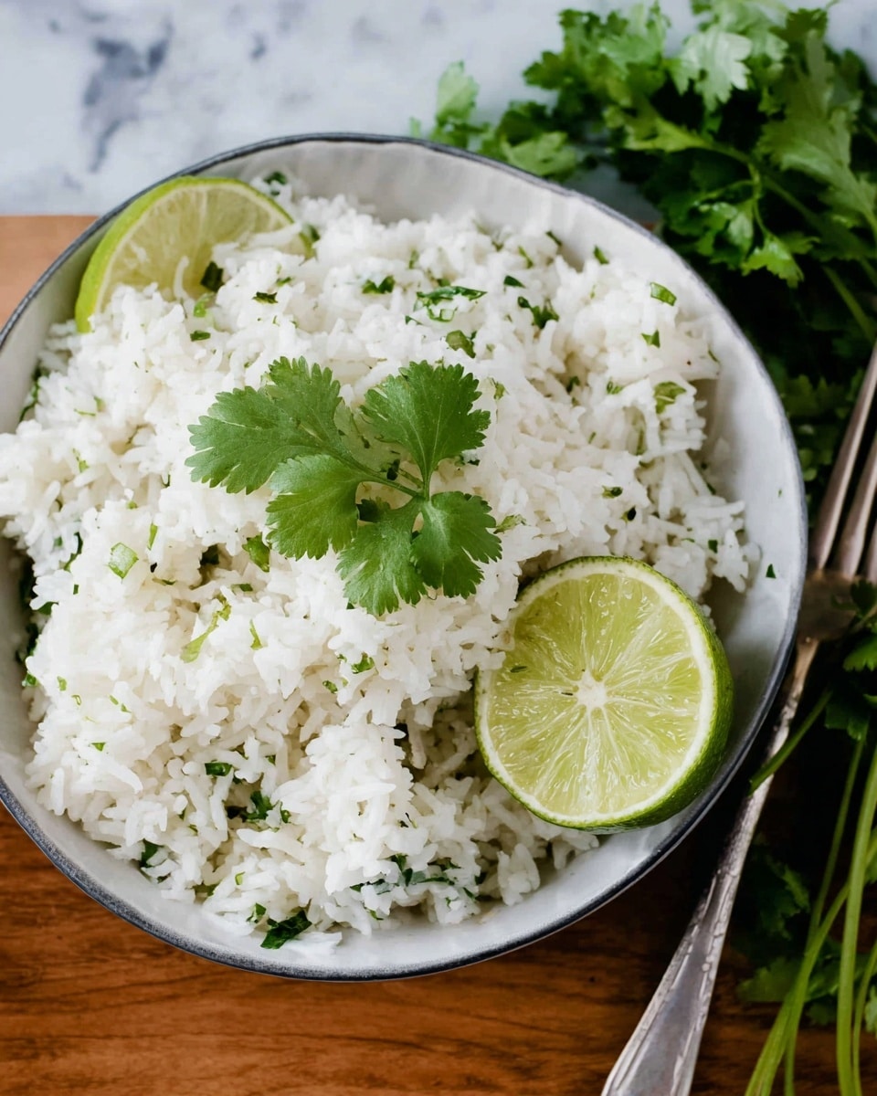 A white bowl filled with fluffy white rice mixed with small green pieces of cilantro, topped with a fresh sprig of cilantro. On the side of the bowl, there is a half lime showing its pale green interior. In the background, a whole lime and some cilantro leaves are visible on a white marbled surface. A silver fork is partially resting on the right edge of the bowl. photo taken with an iphone --ar 4:5 --v 7
