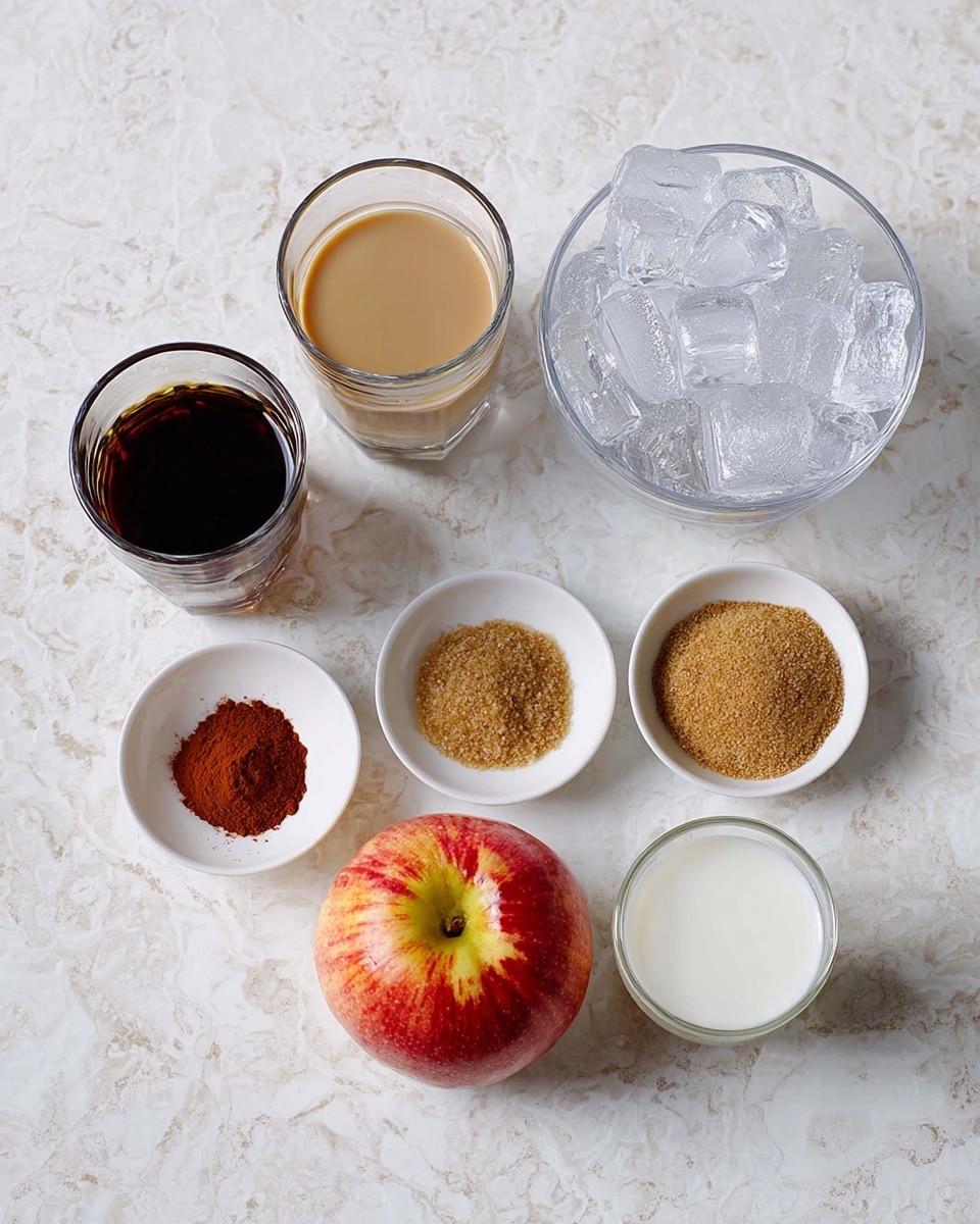 The image shows seven ingredients arranged on a white marbled surface. There are two clear glasses with liquids: one dark brown, probably coffee, and one light beige, which looks like milk or cream. Next to them are three small white bowls containing, from top to bottom, a dark reddish liquid, a cinnamon-colored powder, and a light brown granulated substance that looks like sugar. A large bowl filled with clear ice cubes sits in the top right corner. At the center bottom lies a red apple with some yellow and green shades. Lastly, a small clear glass holding a white liquid is near the apple. All items are neatly spaced and clearly visible. Photo taken with an iphone --ar 4:5 --v 7