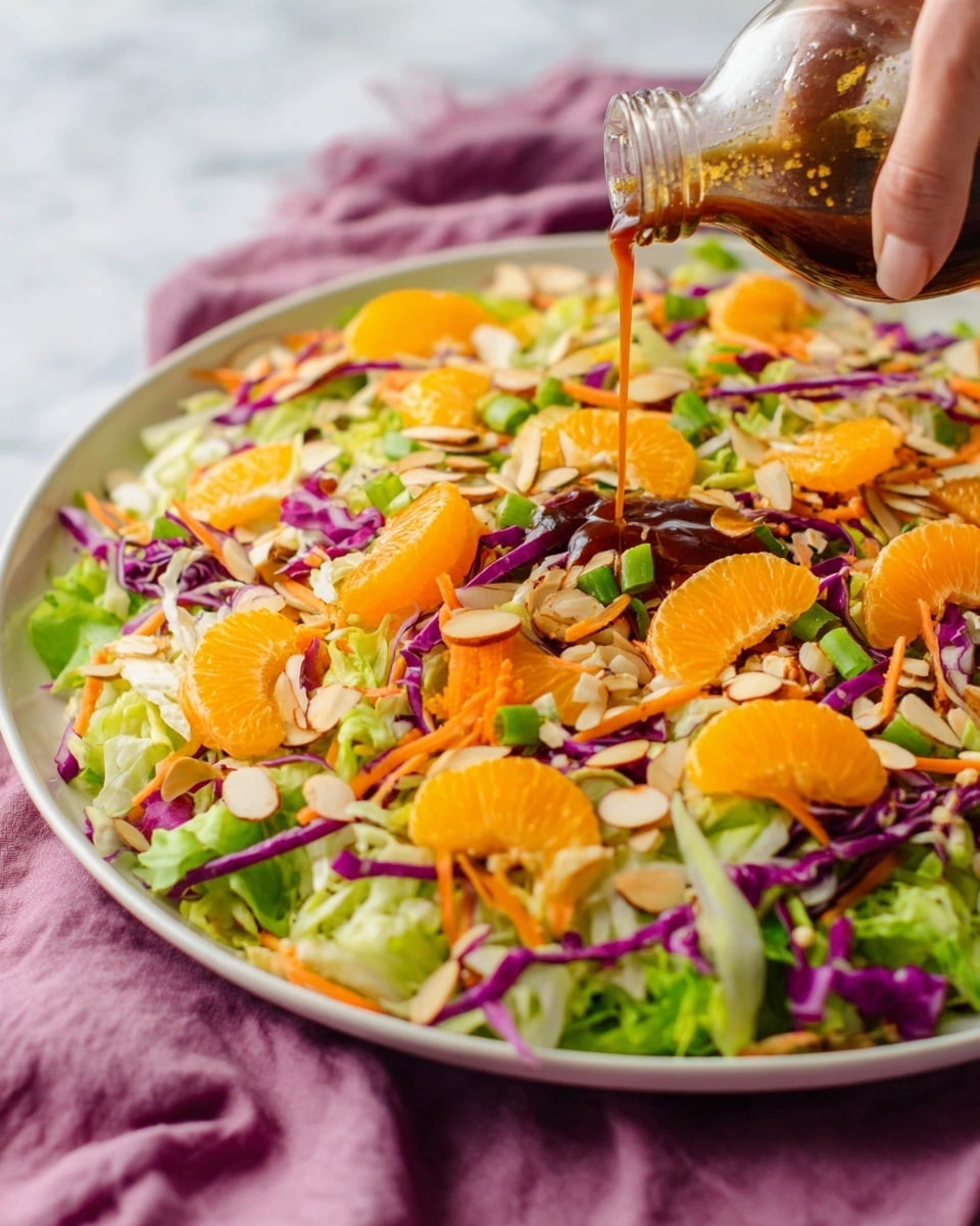 A large white plate holds a fresh salad with several layers starting from shredded green lettuce and purple cabbage at the base. Thin orange carrot strips and sliced green scallions are mixed evenly through the salad. Bright orange mandarin slices are spread on top, adding vibrant spots of color. Sliced almonds add texture and a light tan shade scattered over the salad. A woman's hand is seen pouring a dark brown dressing from a clear glass bottle right onto the salad, creating a shiny drizzle over one bright mandarin slice. The plate sits on a white marbled surface with a soft purple cloth underneath. photo taken with an iphone --ar 4:5 --v 7