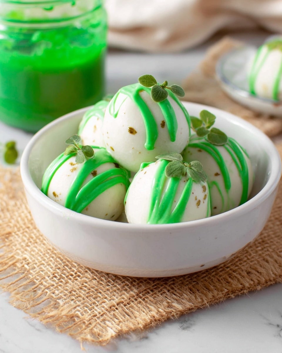 The image shows six round, white-coated snacks placed on a black cooling rack over a white marbled texture background. Each snack has a smooth and slightly uneven white outer layer, sprinkled with a light dusting of green powder on top. The snacks rest on a black wire grid on top of a wooden board, where some white coating has dripped onto the surface. A rustic, ceramic spoon filled with green powder lies diagonally on the bottom left, near a soft beige cloth. The overall look is clean and simple with natural textures. photo taken with an iphone --ar 4:5 --v 7