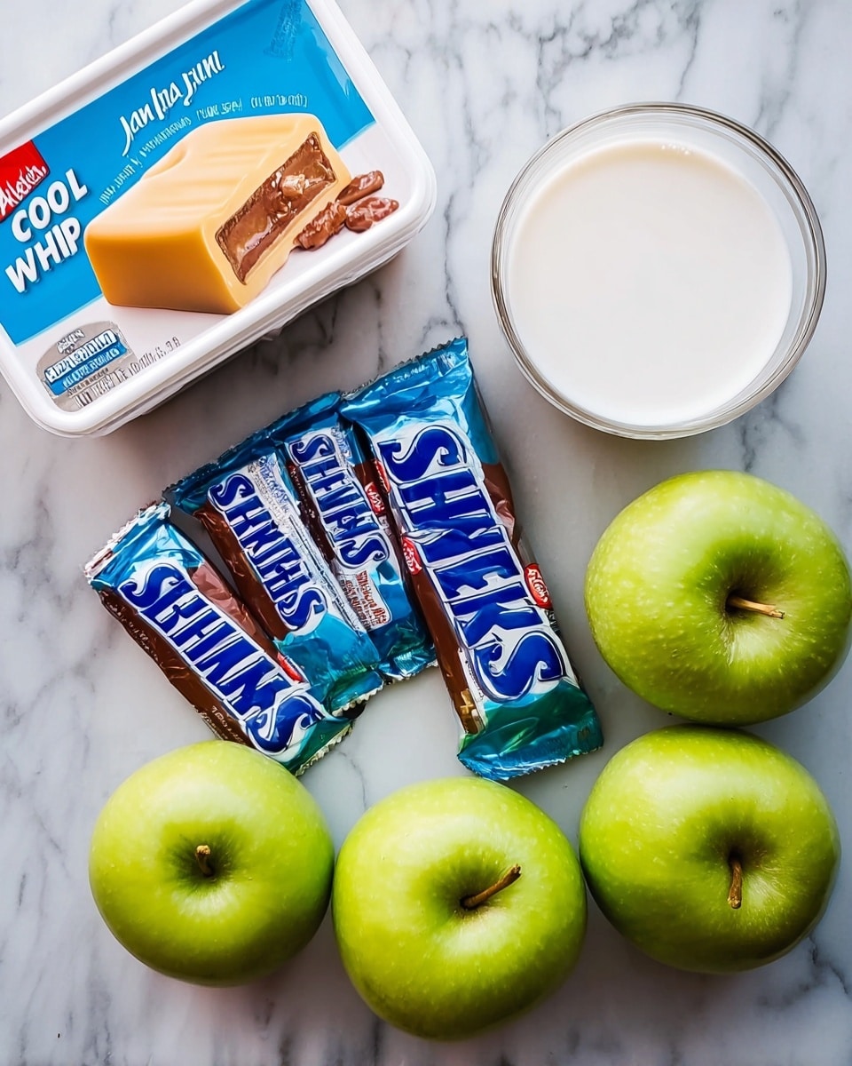 In the image, there are five Snickers bars arranged slightly overlapping on a white marbled surface next to a box of vanilla Jell-O with a creamy yellow pudding picture on it. To the left, there is a white plastic container of Cool Whip original with blue and white labeling. On the right side, there are four bright green apples grouped together, and a clear glass cup filled with white milk is placed near the apples. The colors include dark brown and blue from the candy bars, white from the dairy products, and bright green from the apples, all set on a clean white marbled background. Photo taken with an iphone --ar 4:5 --v 7