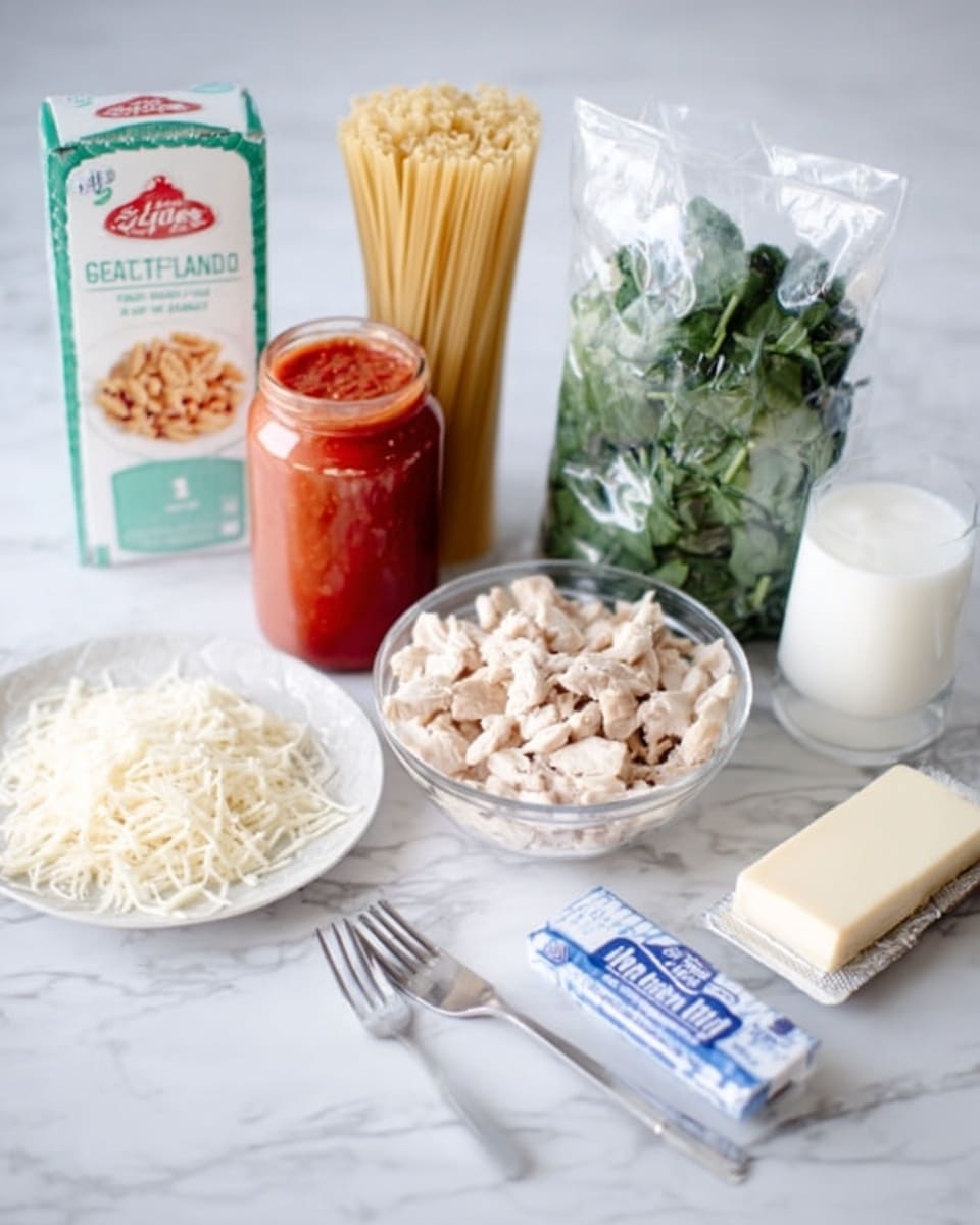 The image shows ingredients for cooking laid out on a white marbled surface. There is a box of pasta standing upright on the left, next to a tall jar of red tomato sauce. In front of the jar is a clear bowl filled with small pieces of cooked chicken. Beside the chicken is a bag of chopped spinach standing upright. To the right of the spinach is a glass of milk. In the front left corner, there is a white plate with a pile of shredded cheese. On the bottom right side, there is a stick of butter in its wrapper. Two silver forks lie flat in front of the chicken bowl. The photo has soft natural light and is clear and bright, showing all items neatly arranged. Photo taken with an iphone --ar 4:5 --v 7