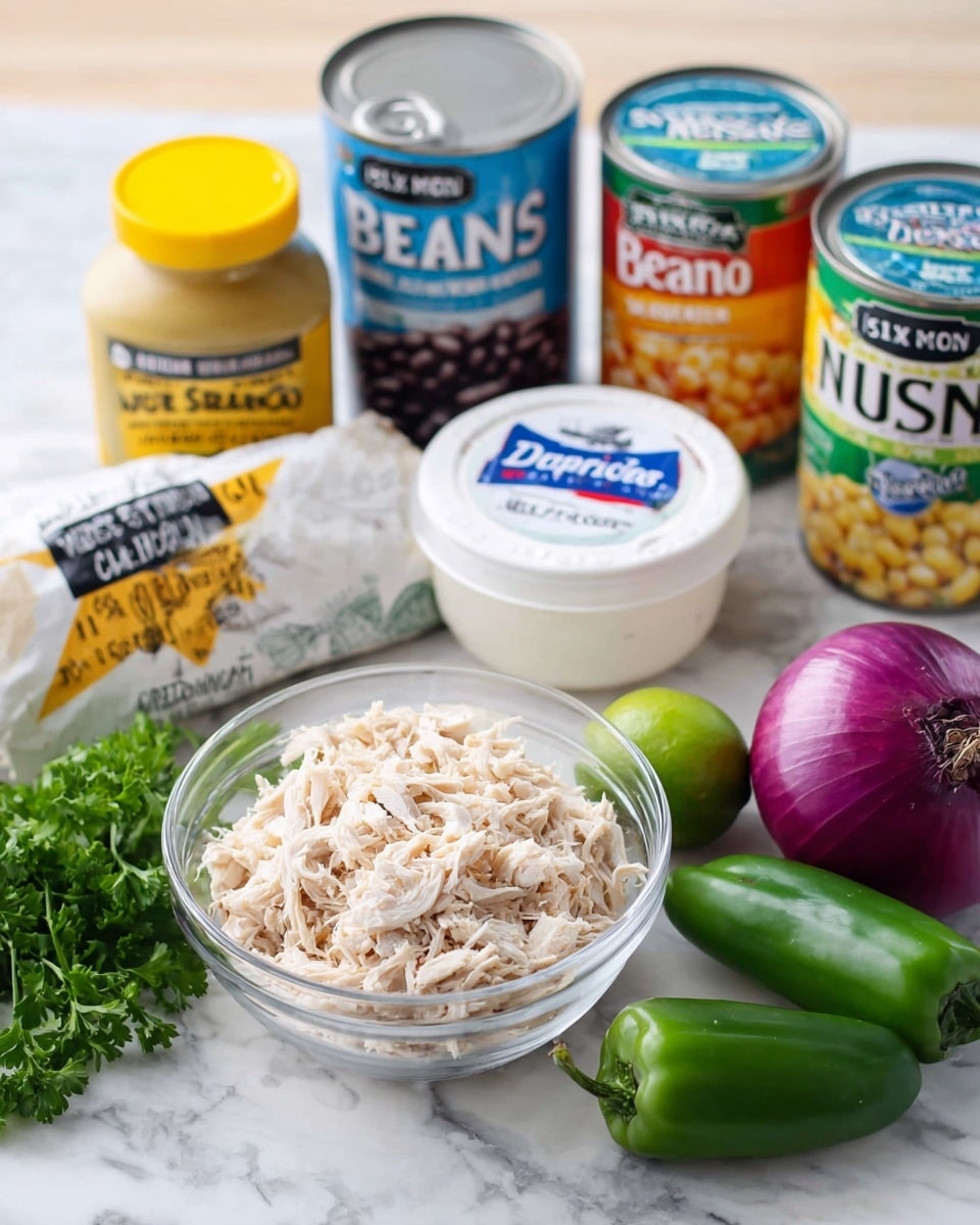 The image shows a set of ingredients on a white marbled surface. In the front center, there is a clear glass bowl filled with shredded light beige chicken. To the right of the bowl, there is a fresh green lime, a purple-red onion, and a green bell pepper neatly arranged. Behind the bowl, there is a white tub of sour cream with a blue and red label, partially overlapping a white bag of Mexican seasoning with black and orange text. Behind the seasoning, there are two cans: one with a blue label of black beans and one with a green label of corn. On the far left, there is a jar of mustard with a yellow lid and label. Some green parsley leaves lay on the white marbled surface near the mustard jar. Photo taken with an iphone --ar 4:5 --v 7