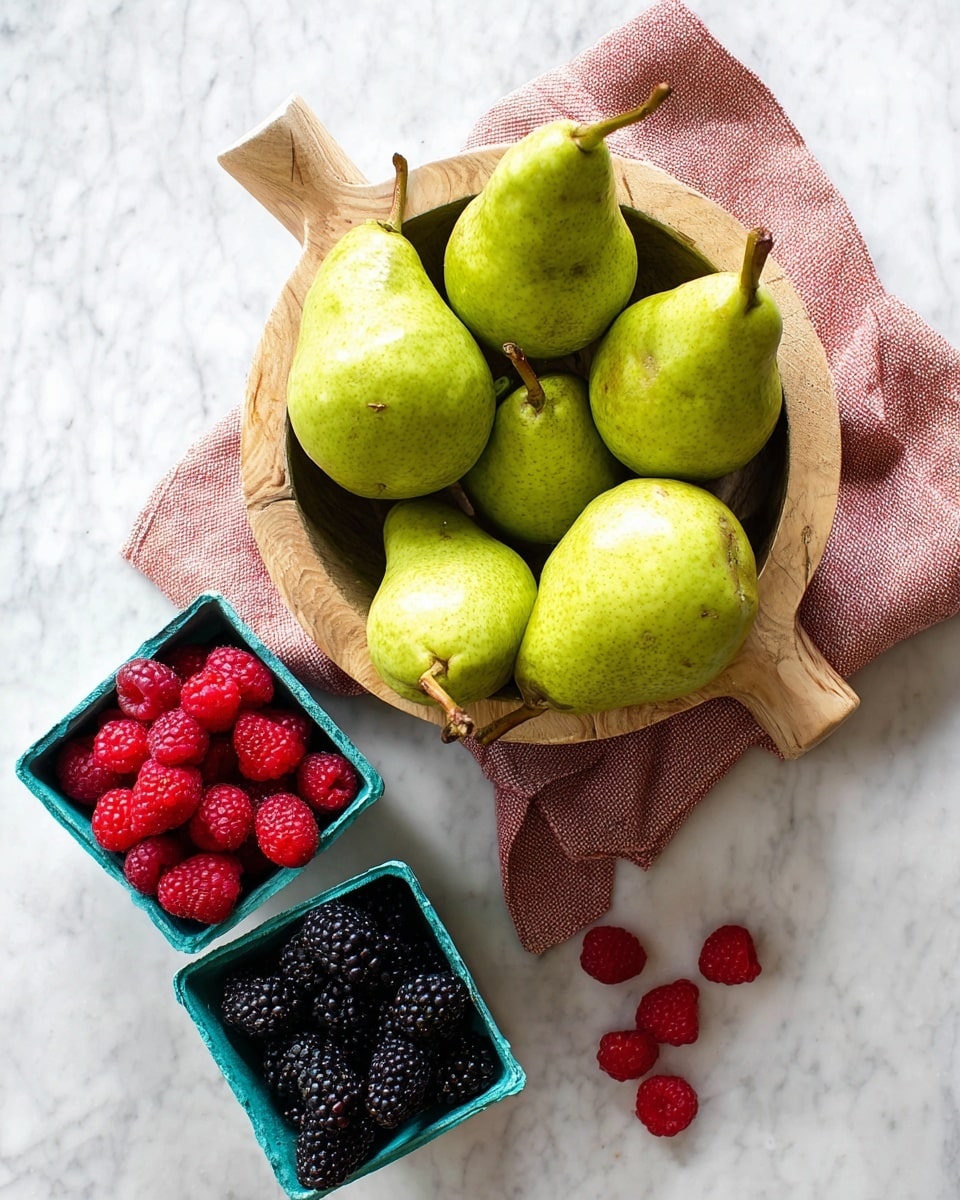 A wooden bowl filled with seven green pears with brown stems sits on a folded light red cloth on a white marbled surface. Below the bowl, there are two small square green containers; one holds a group of dark blackberries, and the other is filled with bright red raspberries, with a few berries spilled onto the white marbled surface near the containers. photo taken with an iphone --ar 4:5 --v 7