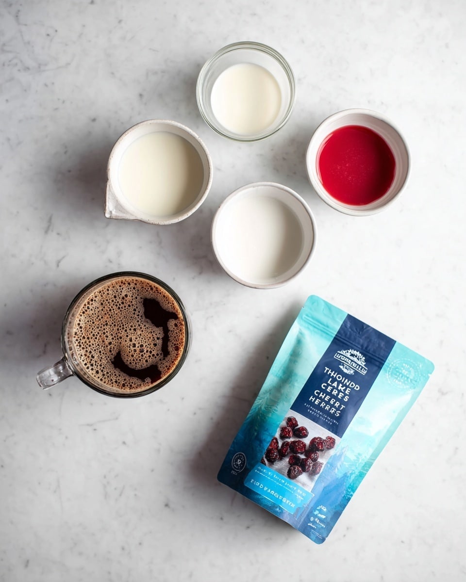The image shows a clear glass jug filled with white liquid at the top left, a small white bowl with white liquid below it, another small white bowl with white liquid further below, and one small white bowl filled with bright red liquid at the top right; in the center, there is a clear glass cup with dark brown frothy coffee. At the bottom right, there is a blue and turquoise packet labeled
