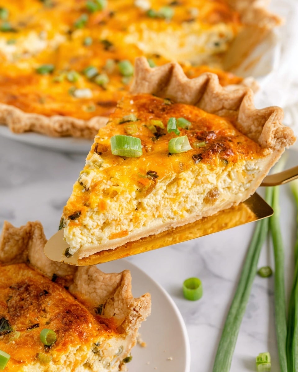 A slice of savory pie with a flaky, golden-brown crust is being lifted by a gold spatula. The pie has two main layers: the crust forms the bottom and edge, light brown with a textured, crimped border, while the filling is a bright yellow-orange mix of melted cheese and bits of green onions scattered on top. The pie rests on a white plate placed on a white marbled surface, with more slices visible around it. Green onion stalks lie nearby, adding a splash of fresh green to the scene. photo taken with an iphone --ar 4:5 --v 7