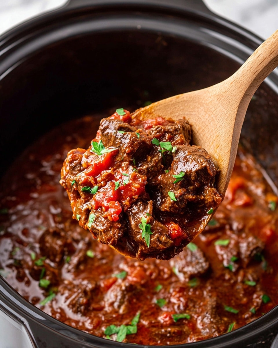 A close-up of a wooden spoon holding thick chunks of dark brown meat stew mixed with small red tomato pieces, all covered in a rich reddish-brown sauce with a glossy texture. Small green herb pieces are sprinkled evenly on top of the meat and sauce, adding a fresh touch. The stew sits inside a black pot with a shiny, slightly reflective interior. The pot is placed on a white marbled surface. photo taken with an iphone --ar 4:5 --v 7