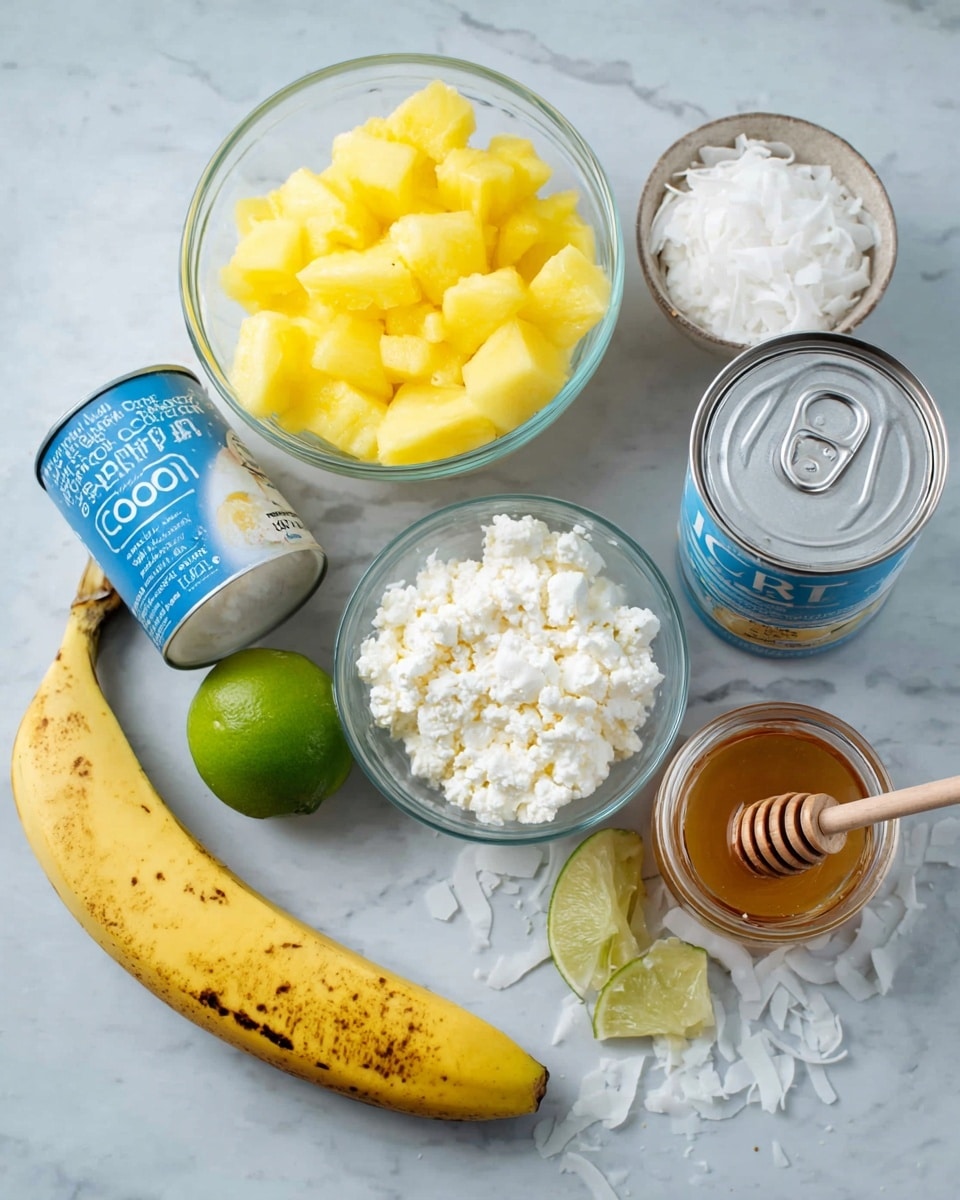 The image shows several ingredients arranged on a white marbled surface: a clear glass bowl filled with bright yellow pineapple chunks sits to the left; next to it is a blue and white container of cottage cheese with a slightly round shape. Above these, there is a small glass bowl with crumbly white cheese, a peeled yellow banana with brown spots lying horizontally, and a halved lime showing its light green inside. A silver can of unsweetened coconut milk with a blue and white label is placed beside the lime, and a small glass jar with honey and a wooden honey dipper rests nearby. Scattered around are white coconut flakes adding texture to the scene. Photo taken with an iphone --ar 4:5 --v 7