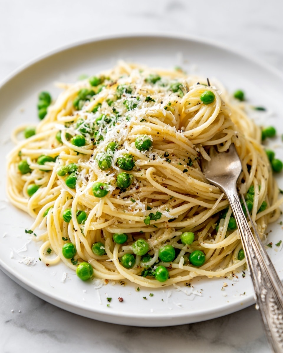 A plate of light yellow spaghetti noodles mixed with bright green peas, topped with a sprinkling of fine white cheese shreds scattered evenly over the top. The spaghetti noodles form a tall, slightly messy pile at the center of the plate, with a silver fork resting on the right side, partly wrapped in noodles. The dish is served on a white plate with wavy edges, placed on a white marbled surface. photo taken with an iphone --ar 4:5 --v 7