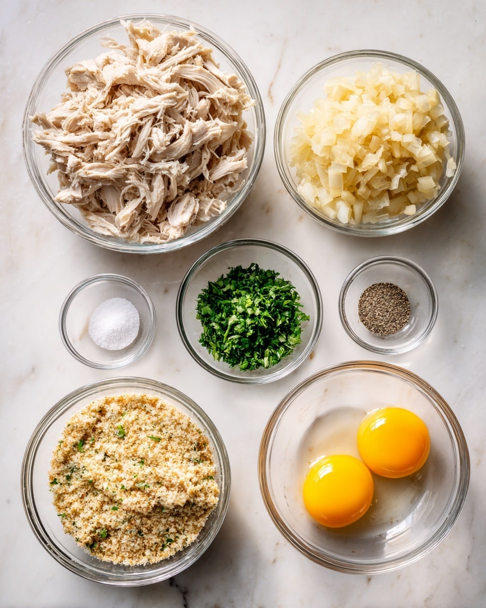 The image shows six clear glass bowls arranged on a white marbled surface. The largest bowl on the left is filled with shredded pale beige cooked chicken. To the right, there is a medium bowl with light yellow cooked diced onions. Below that, a similar-sized bowl contains two raw eggs with bright yellow yolks and clear whites. Below the onions and eggs is a smaller bowl filled nearly to the top with light tan breadcrumbs mixed with tiny green and orange specks. Above the eggs sits a small bowl with chopped fresh green herbs, and next to it is another small bowl divided evenly with coarse white salt and ground black pepper. All bowls have smooth clear glass surfaces. photo taken with an iphone --ar 4:5 --v 7