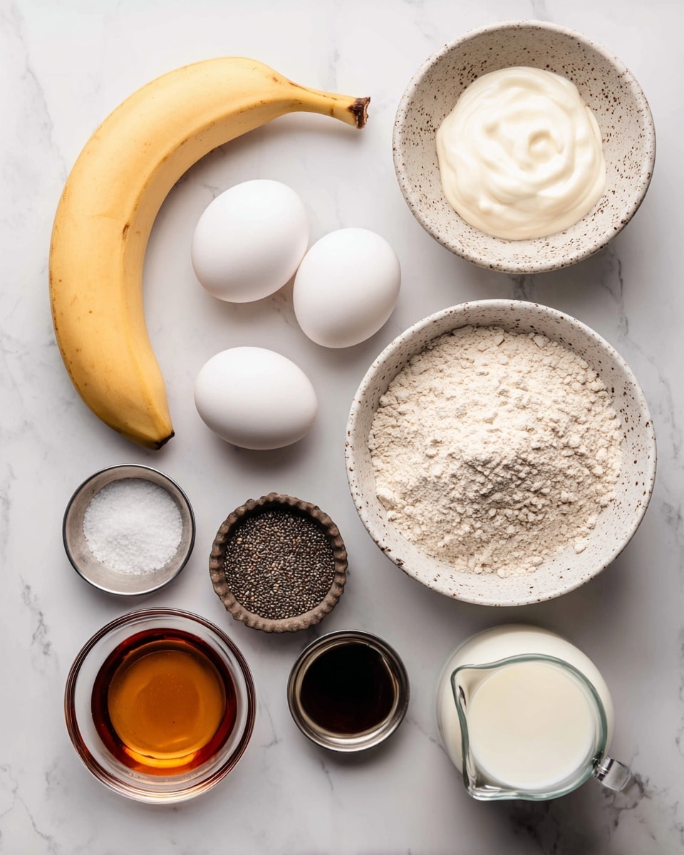 The image shows ingredients neatly placed on a white marbled surface for a recipe. At the top left, there is a peeled banana with a smooth pale yellow color. Next to it on the right is a small white bowl with brown speckles filled with thick, white yogurt. Below the banana, three whole white eggs rest close together. A larger white speckled bowl filled with light beige flour with a slightly rough texture is positioned nearby. To the right of the flour is a dark brown fluted cup holding tiny black chia seeds. Below the eggs, there are two small metal bowls, one with white salt and the other with a white powdery ingredient. To the left of these, there is a small clear bowl with dark brown vanilla extract. Near the bottom center, a larger clear bowl contains amber-colored maple syrup with a smooth surface. At the bottom right, part of a glass jug with white milk is seen. Photo taken with an iphone --ar 4:5 --v 7
