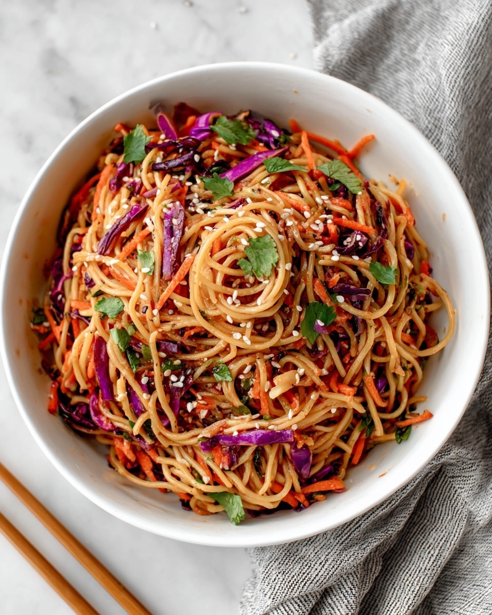 A white bowl filled with a mix of thin brown noodles and shredded vegetables including orange carrot strips, green leafy pieces, and small purple cabbage bits, all lightly tossed together and sprinkled with white sesame seeds. The dish shows a mix of colors and textures, with the noodles forming the main base layer, and the vegetables scattered evenly throughout. The bowl sits on a white marbled surface, next to light wood chopsticks and a folded gray and white striped cloth. Photo taken with an iphone --ar 4:5 --v 7