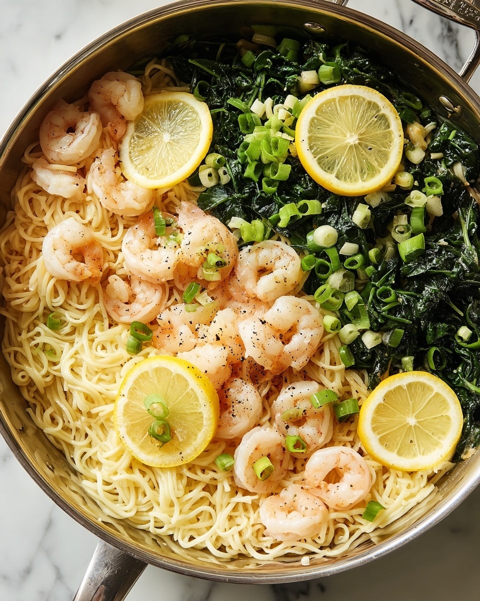A shiny silver pan filled with long, light yellow noodles mixed with small cooked pink shrimp and bright green leafy vegetables. There are thin slices of lemon placed around the dish, adding a pop of yellow. The noodles and shrimp are scattered evenly with chopped green onions and a light sprinkle of black pepper. The pan sits on a white marbled surface, highlighting the colors of the food. Photo taken with an iphone --ar 4:5 --v 7