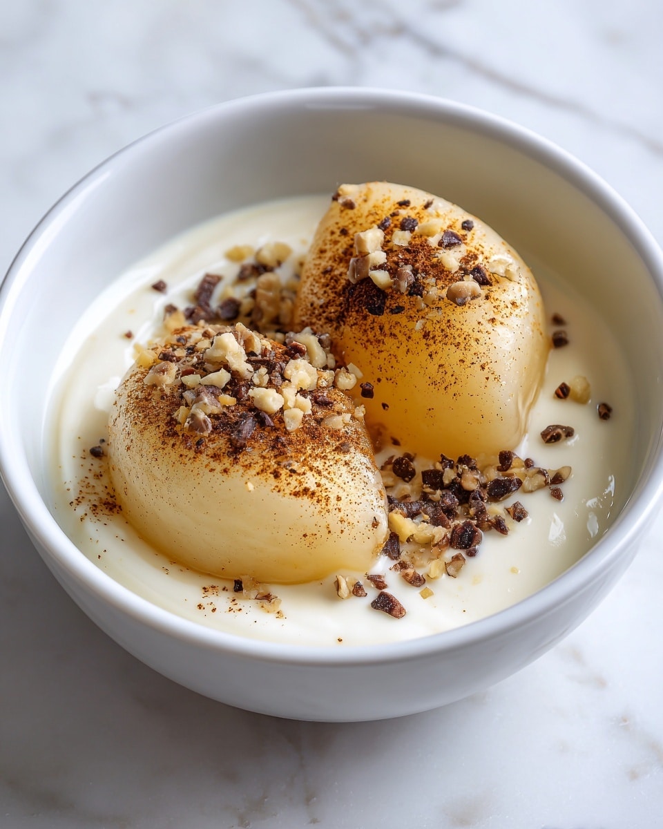 A close-up of a black bowl filled with a light cream sauce, containing two large, soft, beige-colored slices of cooked pear placed side by side. The pears are lightly sprinkled with small, dark brown chopped nuts and a dusting of cinnamon or similar spice. The bowl sits on a white marbled surface, creating a clean and simple background. photo taken with an iphone --ar 4:5 --v 7