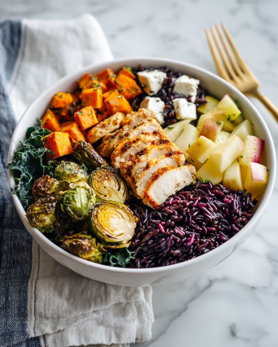 A white bowl sits on a white marbled surface with a white and blue striped cloth beside it. Inside the bowl, there are several layers of colorful food arranged evenly around the bowl. Starting from the back left, there is a light beige grilled chicken layer with grill marks. Moving clockwise, bright yellow and red chunks of roasted sweet potato sit next to it. At the front right, there are dark green Brussels sprouts cooked with a slightly shiny texture. Next to them are roasted orange sweet potato cubes. In the center, there is a cluster of white crumbled cheese with a soft texture. Beneath everything, green kale leaves provide a fresh leafy base. A silver fork is placed to the right of the bowl. The photo taken with an iphone --ar 4:5 --v 7