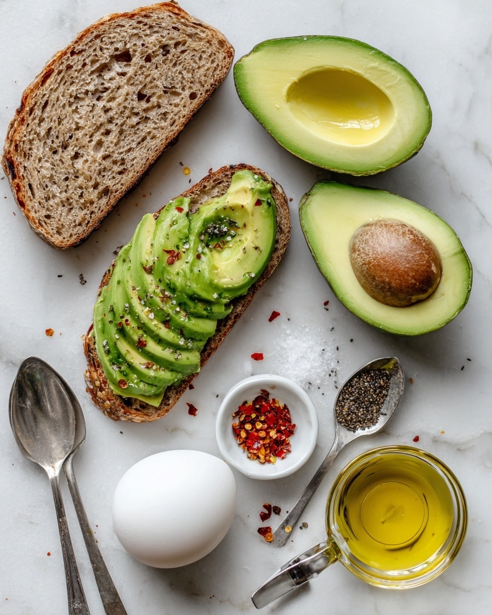 The image shows ingredients for avocado toast arranged on a white marbled surface. There is one slice of whole wheat bread with a rough texture placed near the top left. Two halves of a bright green avocado with a smooth texture and a pit removed sit near the middle and right. Below them, a woman’s hand is scooping the avocado flesh with a spoon. Near the bottom, there is one white egg with a smooth surface, a silver spoon with crushed black pepper, another silver spoon with red chili flakes, and a small measuring cup filled with golden olive oil. photo taken with an iphone --ar 4:5 --v 7