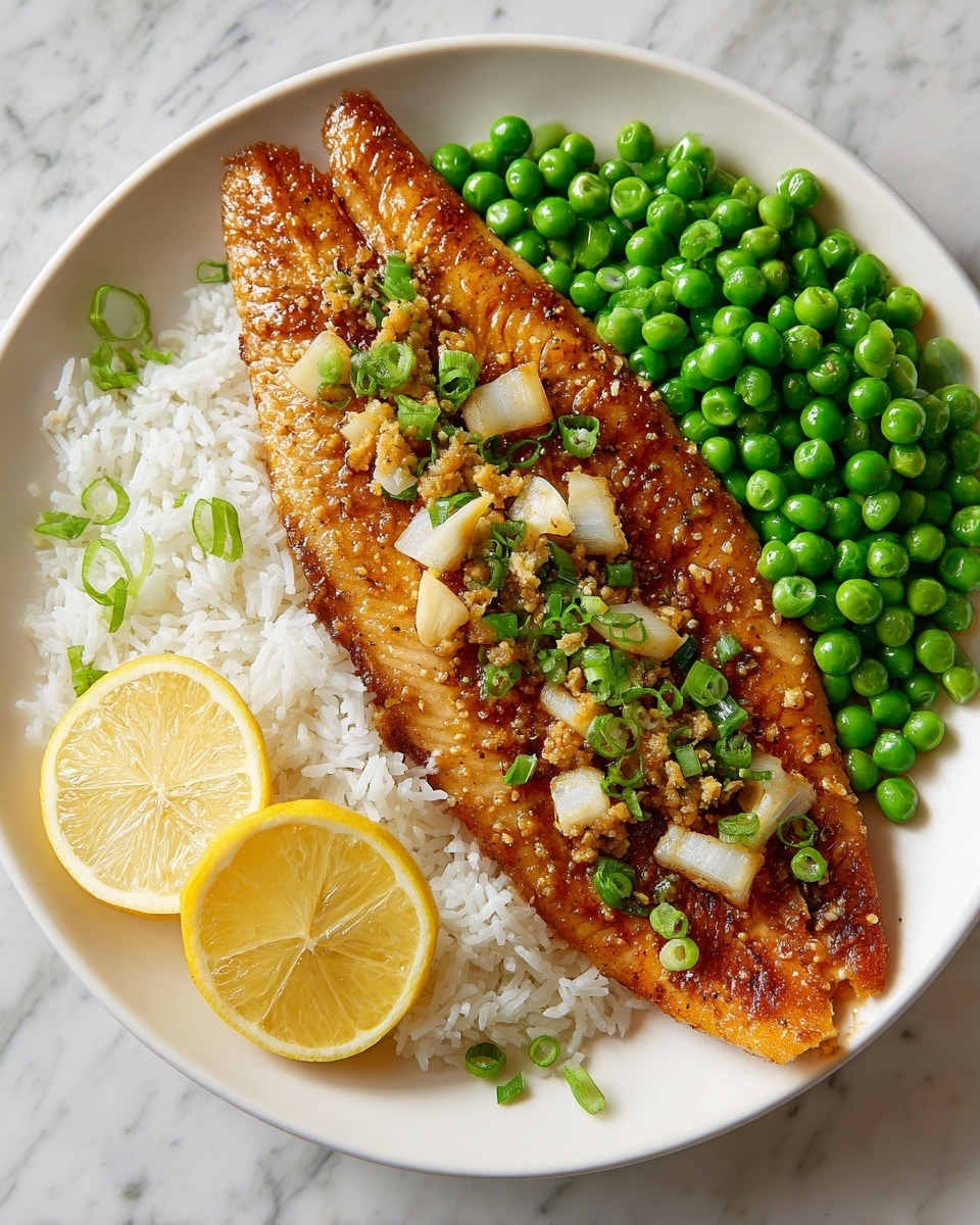 A white plate holds a meal with three main parts. The front layer is a golden-brown cooked fish fillet topped with chopped white onions and green onion slices, with a yellow lemon wedge placed at the bottom right edge of the fish. Behind the fish, on the left side, is a mound of white rice, slightly fluffy and piled compactly. To the right side of the rice, there is a pile of bright green peas, round and fresh-looking. A thin slice of lemon rests behind the rice adding a touch of brightness. The plate is on a wooden round board placed against a white marbled surface. Photo taken with an iphone --ar 4:5 --v 7